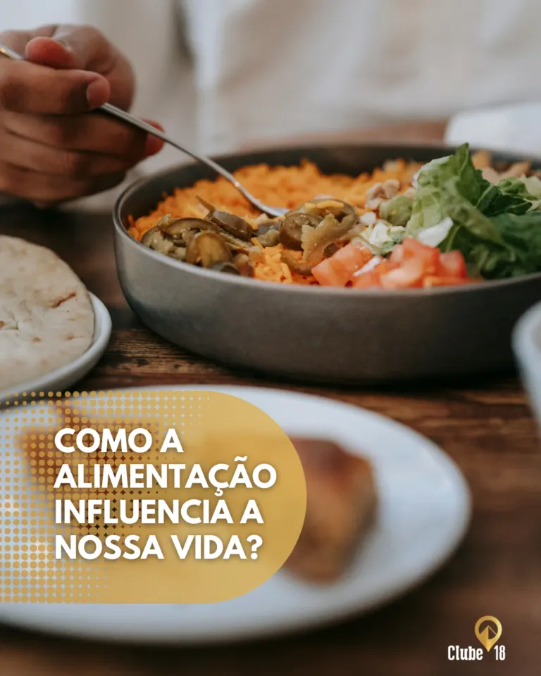 Prato de salada contendo alface, tomate, cenoura, azeitonas e queijo, ao lado de um pão e uma salada no fundo, com texto...