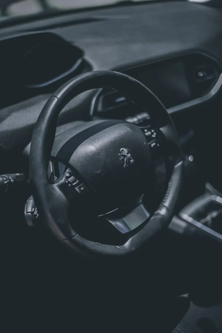 Interior de carro com volante e painel de instrumentos, marca Peugeot