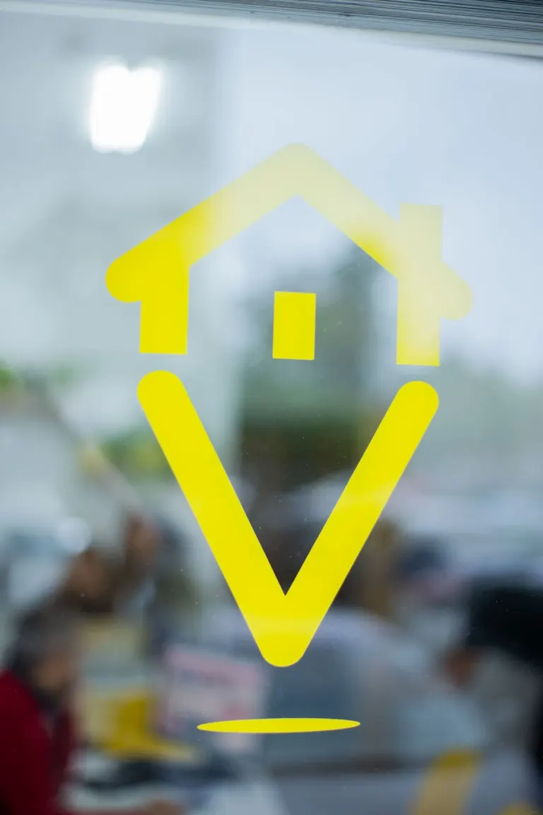 Símbolo amarelo de uma casa em uma porta de vidro.