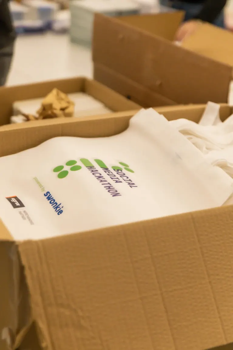 Caixa de papel com sacos de pipoca biodegradáveis da Swankie, com logo e informações de sustentabilidade.