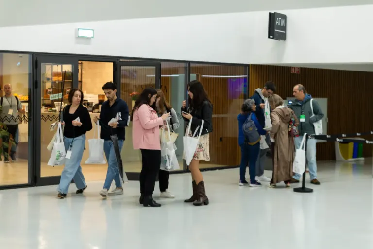 Pessoas na fila para atendimento no caixa de um aeroporto ou terminal de transporte, com sacolas de viagem.