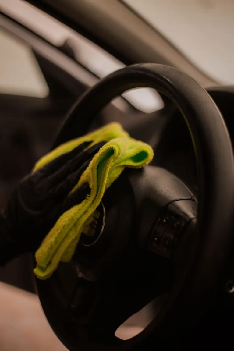 Chaveiro de carro com uma fronha amarela sobre o volante de um veículo, com painel ao fundo.