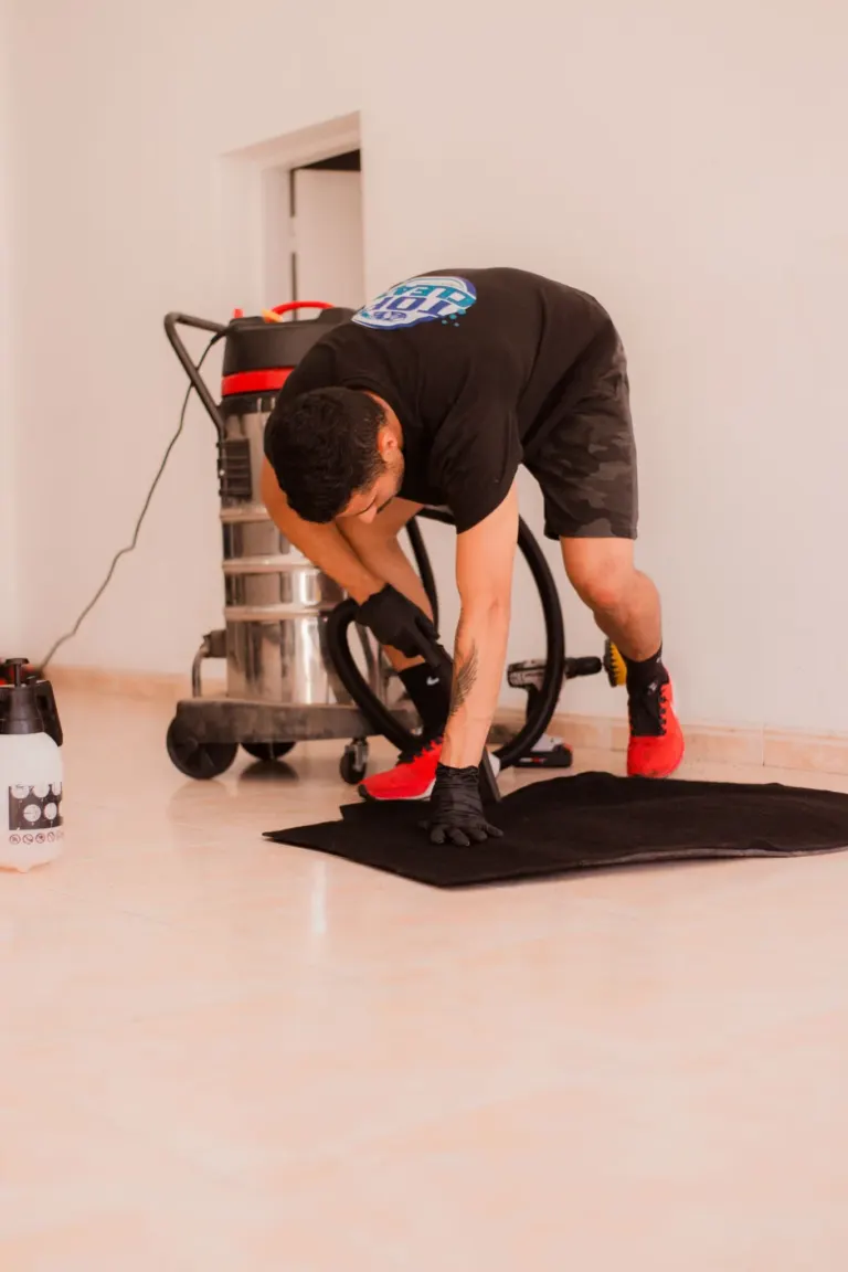 Homem preparando o chão com um aspirador de pó industrial ao fundo